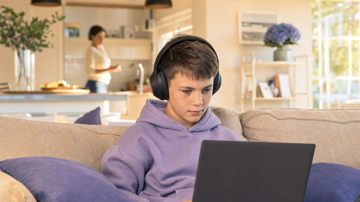 Parent and child sitting together having an open conversation about voices heard during online gaming.